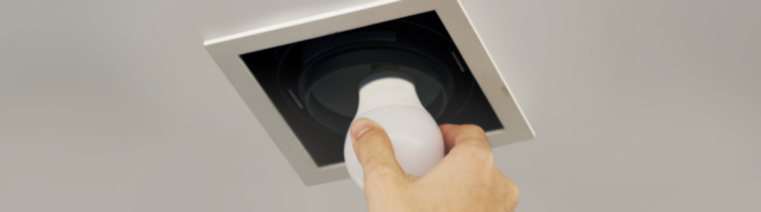 hand installing lightbulb recessed lighting